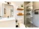 Modern bathroom with walk-in shower, floating shelves, and sleek black fixtures at 3204 Tradewinds Trl, Orlando, FL 32805