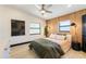Modern bedroom features a ceiling fan, wood accent wall, and neutral color palette at 3204 Tradewinds Trl, Orlando, FL 32805