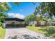 A single story home with neutral colors, carport, and attractive wood accents at 3204 Tradewinds Trl, Orlando, FL 32805