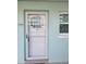 A clean white door with a patterned glass window on a light-blue building wall near a small window at 325 N Causeway # D104, New Smyrna Beach, FL 32169