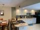 Bright kitchen with white cabinets, sleek appliances, breakfast bar, and an adjacent dining area at 325 N Causeway # D104, New Smyrna Beach, FL 32169
