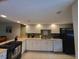 Bright kitchen with white cabinets, modern appliances, tile floor, and plenty of counter space at 325 N Causeway # D104, New Smyrna Beach, FL 32169
