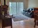 Inviting living room with large windows, tile flooring, and comfortable leather sofa at 325 N Causeway # D104, New Smyrna Beach, FL 32169
