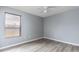 Well-lit bedroom with wood-look floors, a ceiling fan, and a large window at 341 Kirkhill St, Ocoee, FL 34761