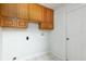 Functional laundry room with light oak cabinets above hookups and tiled flooring at 341 Kirkhill St, Ocoee, FL 34761