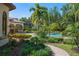 Picturesque backyard view showcasing the pool, lush landscaping, and the outdoor pergola with mature palm trees at 3412 Lilas Ct, Windermere, FL 34786
