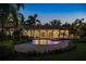 Backyard at twilight featuring a heated pool, spa, landscape lighting, and a covered lanai at 3412 Lilas Ct, Windermere, FL 34786