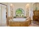 Luxurious bathroom with a standalone tub, tiled surround, and arch window at 3412 Lilas Ct, Windermere, FL 34786