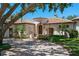 Elegant stucco home with a red tile roof, arched entrance, mature trees, and a circular paver drive at 3412 Lilas Ct, Windermere, FL 34786