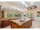 Gourmet kitchen featuring custom wood cabinets, stone counters, stainless appliances, and a travertine floors at 3412 Lilas Ct, Windermere, FL 34786