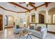 Open living area with travertine floors, beamed ceilings, decorative ironwork, and views of the foyer at 3412 Lilas Ct, Windermere, FL 34786