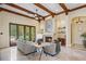 Bright living room featuring beamed ceilings, stone fireplace, travertine floors, and french doors to the backyard pool at 3412 Lilas Ct, Windermere, FL 34786