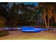 Heated pool at twilight features landscape lighting, rock waterfall, and integrated spa at 3412 Lilas Ct, Windermere, FL 34786