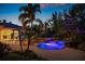 Elegant backyard pool and spa area with LED lighting and lush tropical landscaping throughout the property at 3412 Lilas Ct, Windermere, FL 34786