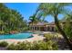 Resort-style pool featuring a rock waterfall, spa, and lush tropical landscaping surrounding the property at 3412 Lilas Ct, Windermere, FL 34786