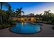 Beautiful home exterior at twilight featuring a luxurious pool, spa and a covered outdoor kitchen and dining area at 3412 Lilas Ct, Windermere, FL 34786
