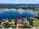 Aerial view of luxurious lakeside home with a pool, boathouse, and meticulous landscaping at 4301 Down Point Ln, Windermere, FL 34786