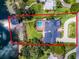 Aerial shot of a lakefront estate with a boathouse, pool, manicured lawn, and circular driveway at 4301 Down Point Ln, Windermere, FL 34786
