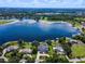 An aerial view of a luxurious lakeside home featuring mature trees, a pool, and a private dock at 4301 Down Point Ln, Windermere, FL 34786