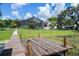Lakeside view of a private dock and walkway with lush landscaping and fenced yard at 4301 Down Point Ln, Windermere, FL 34786