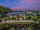 Two-story home boasting lush landscaping, circular driveway, an inviting entryway with elegant exterior lighting at 4301 Down Point Ln, Windermere, FL 34786