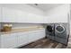 Laundry room features plentiful storage, white cabinets, sink, and modern appliances at 4301 Down Point Ln, Windermere, FL 34786