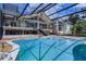 View of the home from the pool area showing large windows and a surrounding screen at 4301 Down Point Ln, Windermere, FL 34786