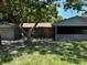 Exterior shot of a single-story home with boarded windows and an attached garage at 4302 Seybold Ave, Orlando, FL 32808