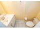 Bathroom includes a white sink vanity, toilet, and light yellow walls at 5060 Downing St # 6, Orlando, FL 32839
