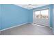 Bright bedroom featuring cool blue walls, a ceiling fan, and durable gray floors at 5060 Downing St # 6, Orlando, FL 32839