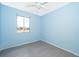 Bright bedroom featuring cool blue walls, a ceiling fan, and durable gray floors at 5060 Downing St # 6, Orlando, FL 32839