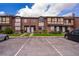 Townhome row with brick facade, parking spaces, and manicured lawns at 5060 Downing St # 6, Orlando, FL 32839