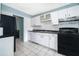 A bright kitchen featuring ceramic tile floor, white cabinets and black appliances at 5060 Downing St # 6, Orlando, FL 32839