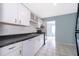 A bright kitchen featuring ceramic tile floor, white cabinets and black appliances at 5060 Downing St # 6, Orlando, FL 32839