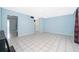 Bright living room featuring tile flooring, light blue walls, and an open layout to kitchen at 5060 Downing St # 6, Orlando, FL 32839