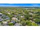 Aerial view of a home with mature trees, a lake and a cityscape in the background at 532 Darcey Dr, Winter Park, FL 32792