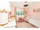 Charming Bedroom with a white crib, comfortable seating, natural light, and elegant décor, creating a serene and inviting space at 532 Darcey Dr, Winter Park, FL 32792