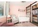 Inviting Bedroom with warm pink tones, white crib, cozy seating area, and stylish closet with sliding door, creating a tranquil ambiance at 532 Darcey Dr, Winter Park, FL 32792