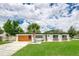 Charming home with a modern garage door, lush lawn, and flower boxes enhancing its curb appeal at 532 Darcey Dr, Winter Park, FL 32792