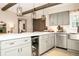 Bright kitchen showcases modern pendant lighting, light gray cabinets, stainless appliances, and an island with beverage center at 532 Darcey Dr, Winter Park, FL 32792