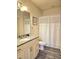 This bathroom features a vanity with granite counter and a shower-tub combo at 5354 Diplomat Ct # 105, Kissimmee, FL 34746