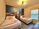 Themed bedroom with two beds, a unique mural, and neutral decor for a comfortable stay at 5354 Diplomat Ct # 105, Kissimmee, FL 34746
