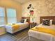 Cozy bedroom with two twin beds, Mickey Mouse decor, and bright, inviting atmosphere at 5354 Diplomat Ct # 105, Kissimmee, FL 34746