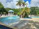 Community pool featuring a splash fountain, lounge chairs, and shaded areas at 5354 Diplomat Ct # 105, Kissimmee, FL 34746
