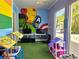 Vibrant playroom with superhero murals, toys, and artificial turf for imaginative play at 5354 Diplomat Ct # 105, Kissimmee, FL 34746