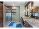Modern bathroom with a glass-enclosed shower, double vanity, and neutral tile flooring at 5388 Birchbend Loop, Oviedo, FL 32765