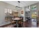 Dining area with dark wood floors, large windows, and a decorative light fixture adjacent to a living area at 5388 Birchbend Loop, Oviedo, FL 32765