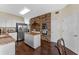 A kitchen offers white cabinets, an island, stainless steel appliances, dark wood floors, and a unique brick accent wall at 5388 Birchbend Loop, Oviedo, FL 32765