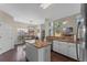 This kitchen boasts white cabinets, granite countertops, stainless steel appliances, an island, and dark wood floors at 5388 Birchbend Loop, Oviedo, FL 32765