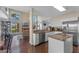 An open concept kitchen features an island, stainless steel appliances, granite countertops, and dark wood floors at 5388 Birchbend Loop, Oviedo, FL 32765